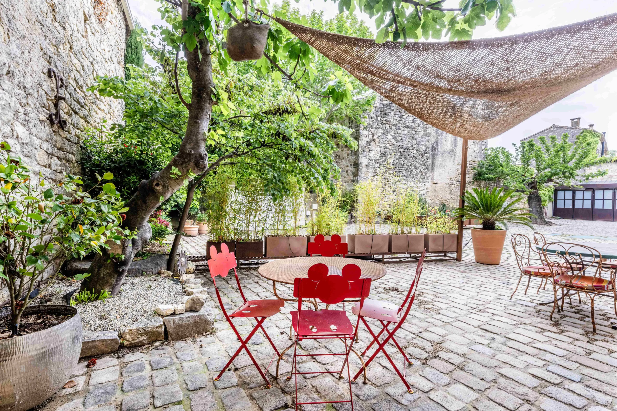 Cour extérieure avec mobilier rouge et plantes.