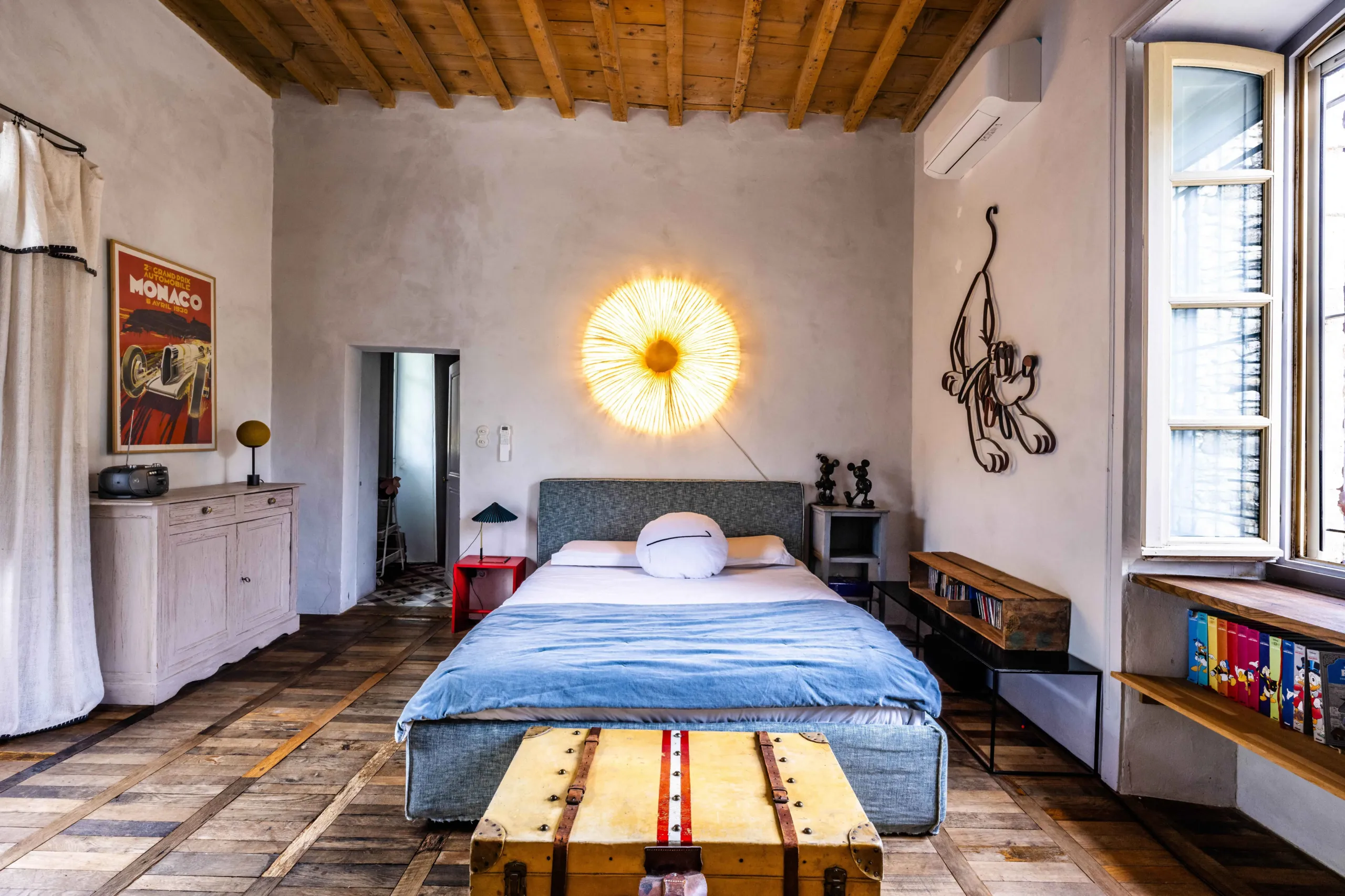 Chambre lumineuse avec déco artistique et lit double.